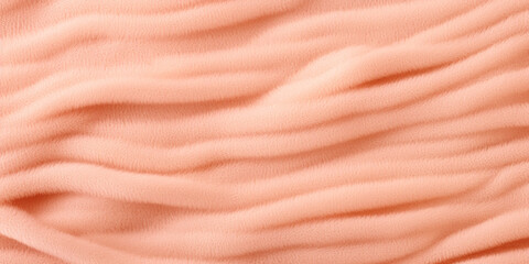 A close up view of a pink blanket. Monochrome peach fuzz background.