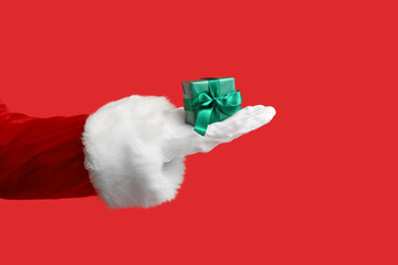 Santa Claus with gift box on red background