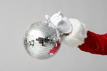 Santa Claus with disco ball on grey background