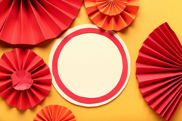 Blank card with paper fans on orange background. New Year celebration