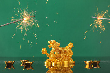 Golden dragon figurine, boats with coins and firecrackers on green background. New Year celebration