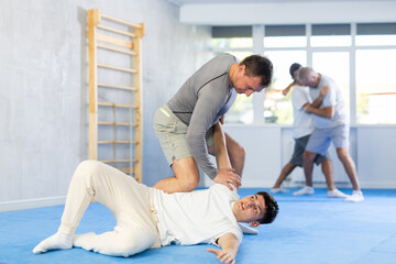 Guy and man during one-on-one training fight are engaged in martial arts section. Fostering strong...