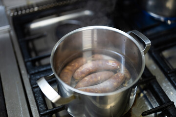 Cooking Boiled Sausages in a Pot on a Stove Close Up