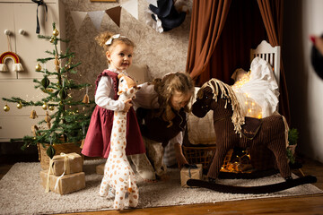 cute baby girl sitting in children's room, on bed at home with toy animal