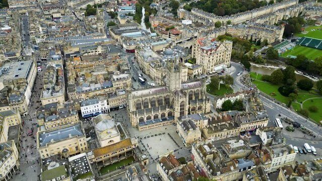 Top cinematic aerial view to the Georgian City of Bath and Bath Cathedral, Somerset, England. Pulteney Bridge and Weir on the river Avon, Bath, Somerset, England.