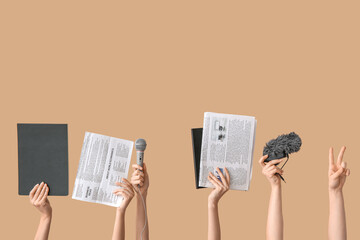 Female hands with newspapers, notebooks and microphones on color background