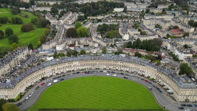 Top cinematic aerial view to the Georgian City of Bath and Bath Cathedral, Somerset, England. Pulteney Bridge and Weir on the river Avon, Bath, Somerset, England.