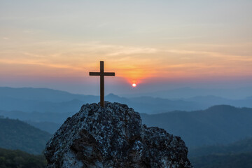 Silhouettes Crucifixion cross on top mountain with sunset background.religion and christianity...
