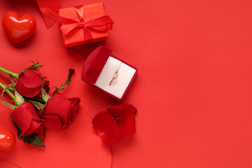 Beautiful composition with engagement ring and rose flowers on red background. Valentine's day...