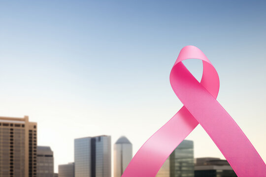 The large pink ribbon for breast cancer in the foreground: A symbol of hope in the city on World Cancer Day