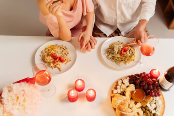 Top view, couple sitting at table with food and candles romantic date, celebrating valentine's day