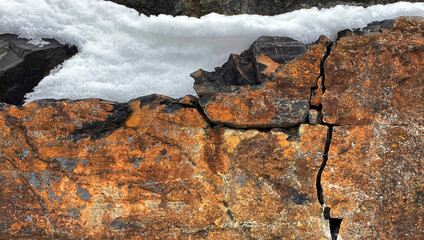 Cracked Iron-Rich Rock Capped wjith Snow