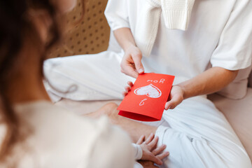 Portrait of couple in love, man holding red card, happy valentines day, selective focus, closeup