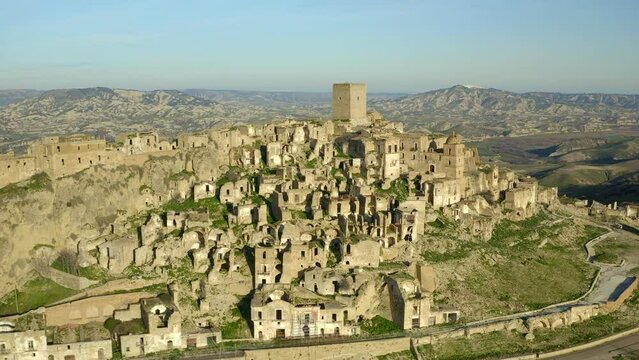 Drone aerial view of Craco abandoned village on top of a rock and dry landscape in the south of Italy