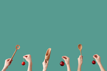 Hands holding cooking utensils and Christmas decorations on green background