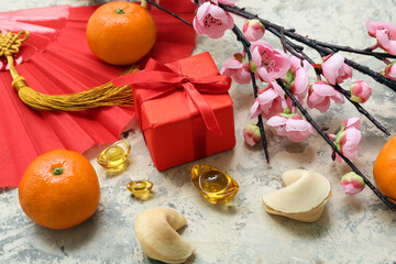 Gift box with fortune cookies, mandarins and Chinese symbols on grunge background. New Year...