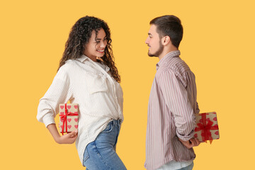 Young couple greeting each other with Valentine's day on yellow background