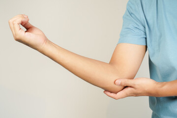Health concept, person with elbow pain, man holding hand on elbow with pain, bone arthritis - obrazy, fototapety, plakaty