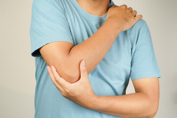 Health concept, person with elbow pain, man holding hand on elbow with pain, bone arthritis