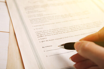 Woman signing Last Will and Testament at table, closeup - obrazy, fototapety, plakaty