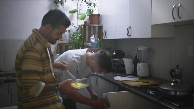 Breakfast, cleaning and friends in the kitchen of their home together for morning housework. Flatmate, daily routine and young people in an apartment for cooking food, housekeeping or hygiene