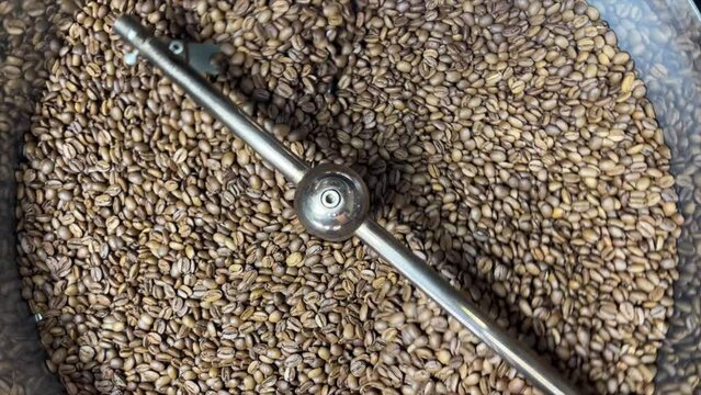 Freshly roasted coffee beans in the state-of-the-art roasting machine at our premium roastery facility, ensuring unparalleled quality and aroma for your perfect cup of coffee. Immerse yourself in the 