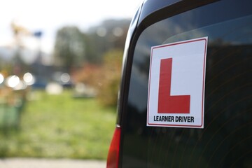 L-plate on car outdoors, closeup with space for text. Driving school - obrazy, fototapety, plakaty