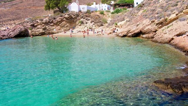 Paralia Agios Sostis wild and free beach in the north of Mykonos, Greece. Pristine bay with blue sea and crystal water, famous for naturism and Kiki's Tavern, peaceful and quiet. Gimbal cinematic