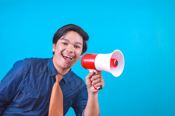 Excited young Asian business guy making announcement with megaphone in hands