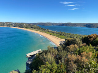 Narrow peninsular is surrounded by water on two sides. Panorama of the ocean. View of the beach and the island's coastline. Palm beach, Australia, NSW. Beach that divides the ocean.