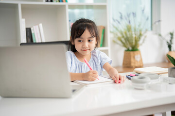 Photo of young Asian baby girl studying at home