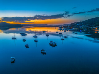 Fototapeta premium Aerial sunrise waterscape with boats, reflections and low cloud