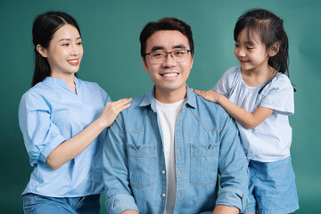 Photo of young Asian family on background