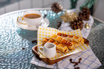 Cup of hot coffee and bakery goods Various waffles and breads are on the table. and decorated with Christmas There is a Christmas tree and various decorations. to celebrate the Christmas festival.