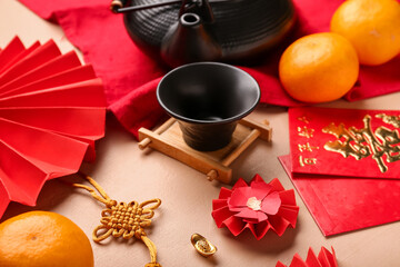 Cup with envelopes, mandarins and oriental symbols on beige background. New Year celebration