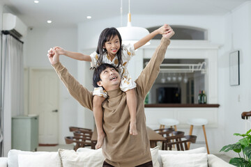 Young father playing with cute daughter sitting up on neck to fly like plane open arms leisure...