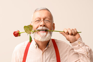Mature man with rose flower on white background. Valentine's day celebration