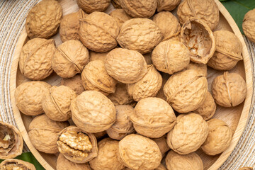 Walnuts in wooden tral on wooden background, Walnuts kernels on wooden table.