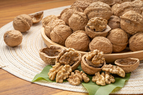 Walnuts in wooden tral on wooden background, Walnuts kernels on wooden table.