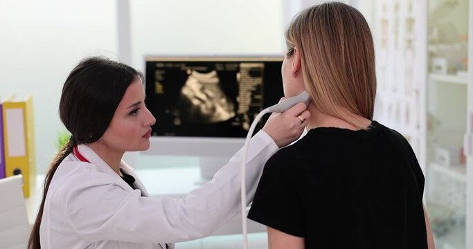 Closeup of woman having ultrasound scan of neck by doctor