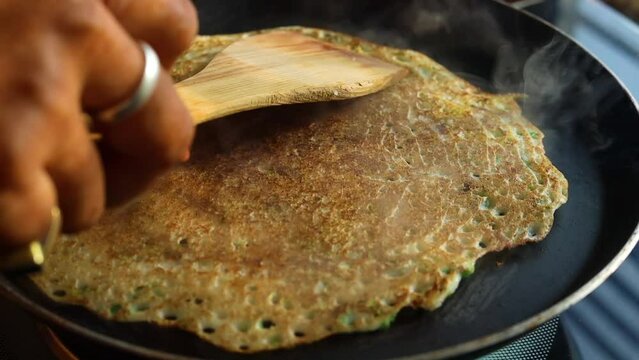 Dosa making on pan rice batter with green chilli, south indian food