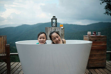 Asian family, mum and child playing together, leisurely relax in bathtub, enjoy happily with...