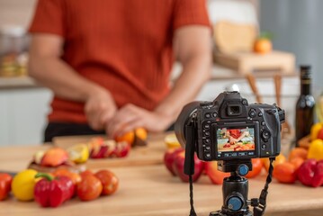 videographer record video clip back screen video recording by camera and smartphone to online social internet live. Vlogger watching recording clip streaming online a man preparation food salad.