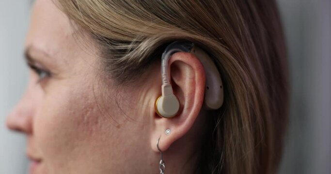 Closeup of woman with hearing aid in ear