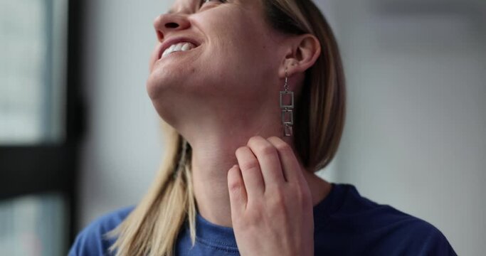 Closeup of unhealthy young woman with allergy symptoms and scratching neck