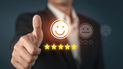 
Businessman showing thumbs up to give five glowing golden stars and smile face icon for excellent...