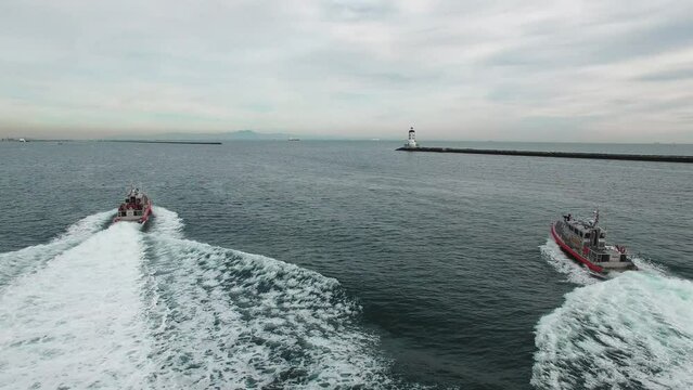 Drone footage of coast guard boats sailing with Los Angeles Harbor Lighthouse in the background