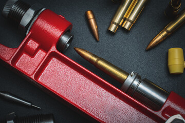 Reloading rifle cartridges, hand press and 7.62x39mm caliber cartridge.  Close-up photo.