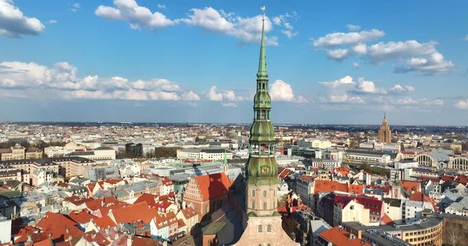 Aerial shot featuring Riga's St.Peters church, Stone Akmens bridge, Railway Dzelzceļa bridge, Van&scaron;u bridge, river and oldtown. Panoramic rotating 4k prores footage in daylight of Latvia capital city