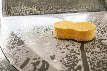 car cleaning and washing with yellow sponge and foam soap